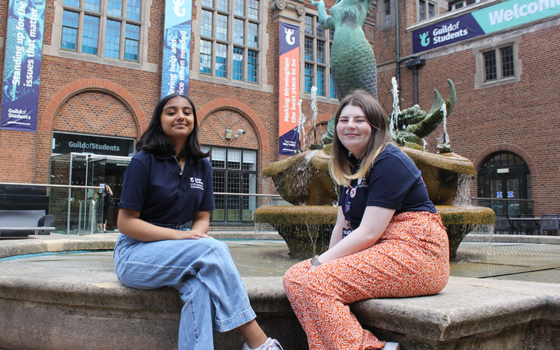 a photo of 2 student staff members sat in mermaid square