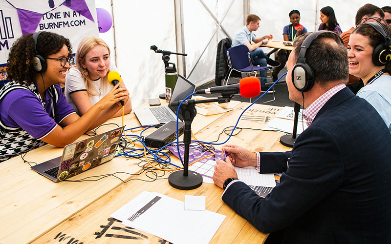 a photo of a group of students hosting a radio broadcast